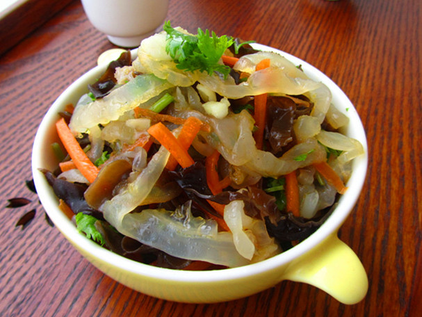 海蛰一直被视为宴席上的佳肴,它不仅营养价值较高,食之可以补碘,还可以能扩张血管,降低血压,对防治动脉粥样硬化也有一定功效。但大家都忽略它另外一个功效,那就是海蜇适宜醉酒后烦渴者食用,所以凉拌海蜇不仅是日常生活普通小菜,也是朋友聚会喝酒时的爽口、解腻的一道上乘选择菜。即使是您没喝醉,酒足饭饱之余,作为宴席的最后一道爽口解腻小菜是不是也会让吃得很舒心呢? 但是家里从超市中买回来的海蜇皮如果不仅处理,直接凉拌,不是发腥,就是凉拌后出水较多,总是没有饭店做出来好吃。其实那是因为我们买回来的海蜇丝,一般都是盐水泡发